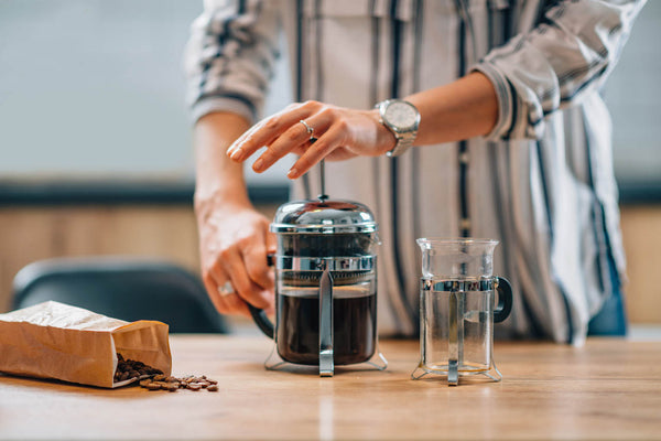 french press ile filtre kahve demleyen kadın