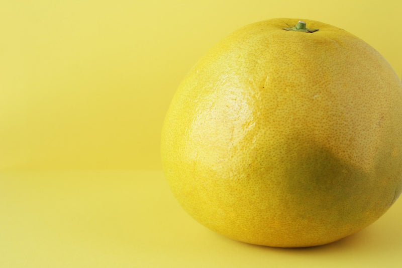 Pomelo nedir-sarı arka plan önünde bütün bir pomelo meyvesi